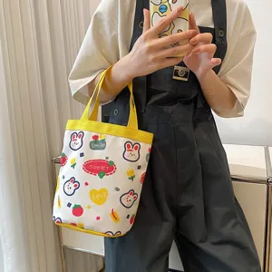 Cute cartoon canvas lunch tote bag with rabbit patterns held by a stylish model