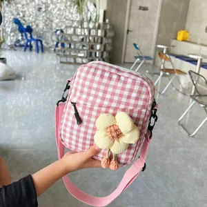 Primer plano del mini bolso bandolera de cuadros rosa y blanco con una flor de felpa amarilla