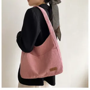 Close-up of stylish pink corduroy tote bag with large capacity for school and work