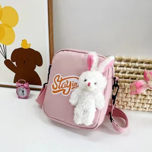 Vista detallada del bolso bandolera rosa con un lindo conejito de peluche blanco.