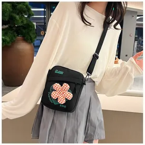 Elegante bolso bandolera preppy negro con flor de cuadros usado por una modelo mujer.
