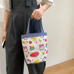 Handheld detail of a cute cartoon canvas tote bag with rabbit and strawberry prints