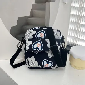 Vista detallada de un bolso bandolera de nailon con estampado de oso de dibujos animados