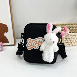 Bolso bandolera negro de dibujos animados con un lindo colgante de conejo blanco