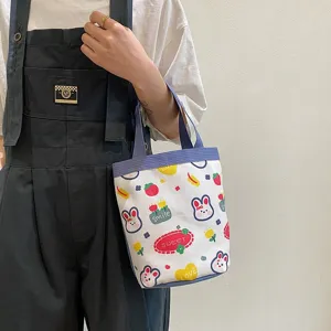 Cute cartoon canvas lunch bag with rabbit and strawberry prints held by model