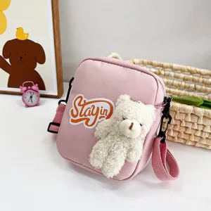 Detalle del bolso bandolera de nailon rosa con osito de peluche y parche Stayin