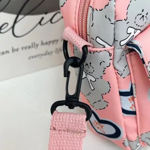 Detalle del estampado de oso de dibujos animados y el gancho de correa en un bolso de nailon rosa