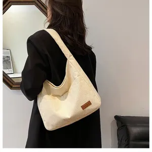 Detailed macro view of cream corduroy tote bag showing textured vertical stripes and strap