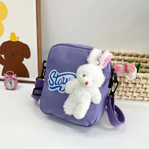 Primer plano de un lindo bolso bandolera japonés morado con un conejito de peluche.