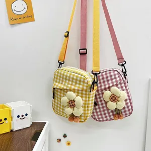 Detalle de mini bolsos bandolera a cuadros con linda decoración de flores 3D en amarillo y rosa.