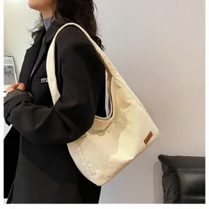 Detailed side view of white corduroy shoulder bag with premium textured stripe finish