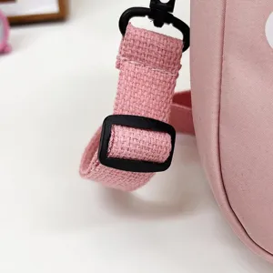 Primer plano de la correa tejida rosa y la hebilla de plástico de un bolso de nylon