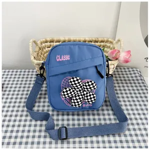 Elegante bolso bandolera azul para mujer con un adorno de flor a cuadros muy original.