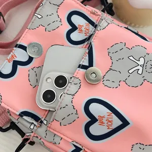 Primer plano de bolso rosa con estampado de dibujos animados que muestra bolsillo frontal.