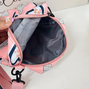 Vista detallada del interior de un bolso bandolera de nailon rosa con dibujos
