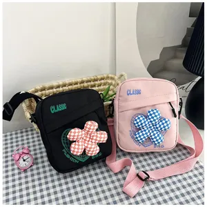 Vista detallada de los bolsos bandolera rosa y negro con un diseño de flor a cuadros 3D
