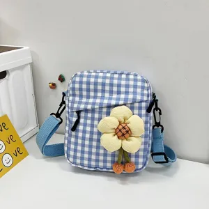 Detalle del mini bolso bandolera de cuadros azules y blancos con aplique de flor