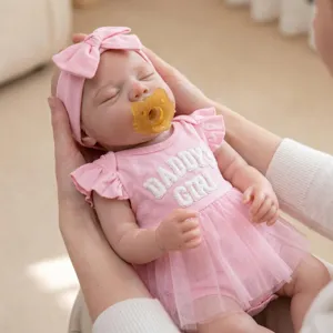 Realistic 18-inch reborn silicone baby doll in a pink tutu skirt and bow headband.