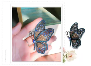 Detailed macro view of an ornate blue and brown rhinestone butterfly brooch on a hand