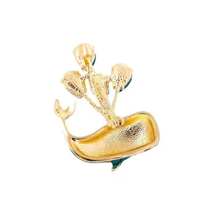 Back view of a gold-plated cartoon whale brooch with balloon motifs for women