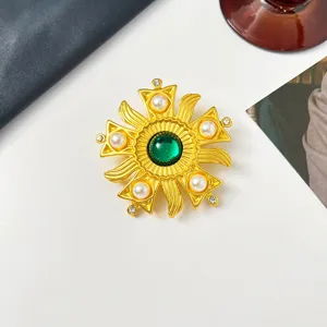 Nahaufnahme einer wunderschönen goldenen Vintage-Brosche mit grünem Glasperle.
