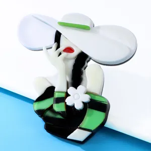 Detailed macro view of an elegant lady acrylic brooch featuring green and black textures.