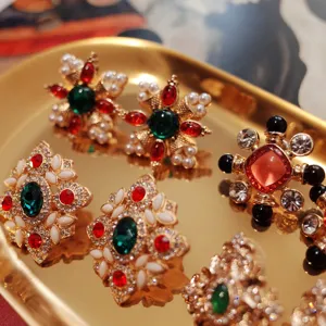 Macro view of vintage baroque earrings with colorful gemstones on a golden tray