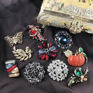 Detailed view of assorted vintage Baroque crystal brooches displayed on silk with ornate box