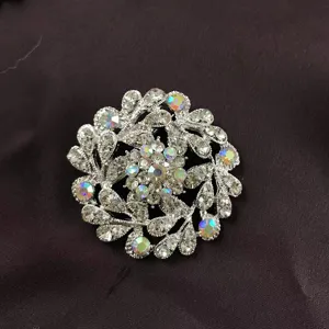 Macro detail of a vintage baroque silver brooch featuring sparkling iridescent crystals
