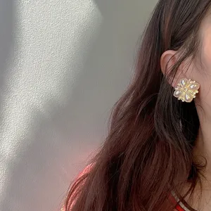Detailed close-up of vintage Baroque flower earrings with pearls worn on model ear