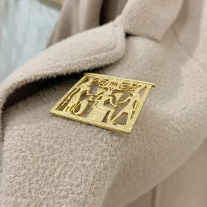 Close-up of vintage gold Egyptian style brooch pinned on a beige wool coat