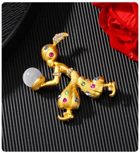 Gedetailleerde weergave van gouden Sultan-broche met gekleurde strass en witte kraal