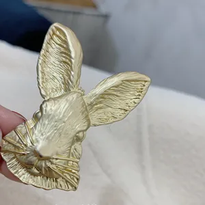 Detailed close-up of vintage Baroque gold rabbit head brooch with textured finish