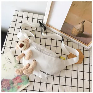 Detailed view of white canvas chest bag with cute plush bear and adjustable strap