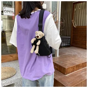 Stylish black canvas sling bag for women featuring a cute 3D plush bear ornament