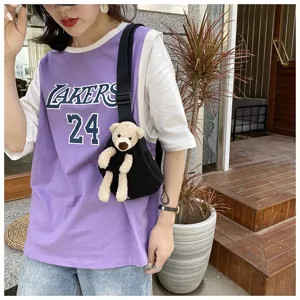 Close-up view of a casual black canvas chest bag with a cute plush teddy bear detail