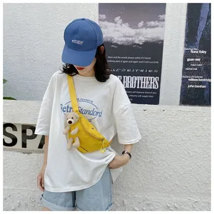 Asian model wearing a yellow canvas chest bag with a cute teddy bear plush accessory