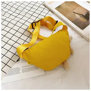 Detail view of yellow canvas waist bag showing adjustable strap and texture.
