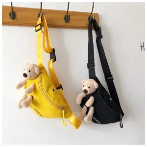 Close-up view of yellow and black canvas fanny packs featuring cute teddy bear decor