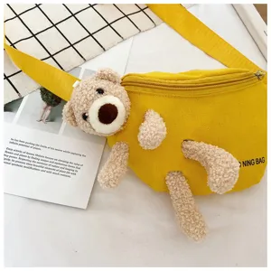 Detailed close-up of a yellow canvas chest bag featuring a cute plush bear attachment