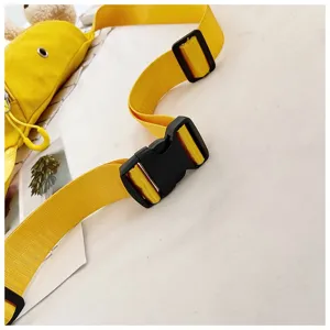 Close-up detail of adjustable black plastic buckle and yellow nylon strap on canvas bag