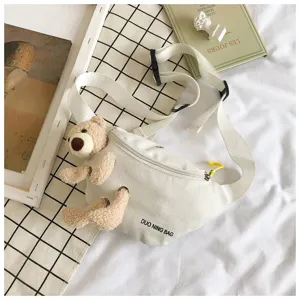 Macro view of white canvas waist bag featuring a cute stuffed teddy bear doll accessory