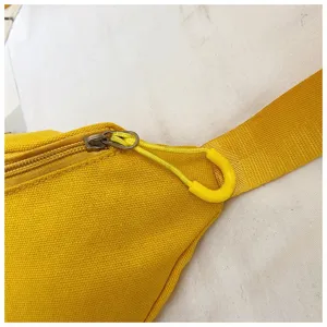 Close-up detail view showing the zipper and strap of a vibrant yellow canvas waist bag