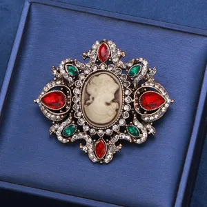 Detailed macro shot of a vintage court cameo brooch with red and green crystals