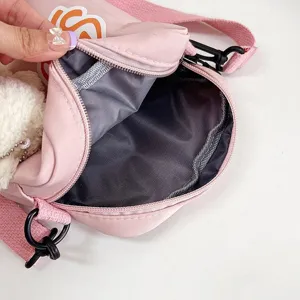 Detalle del forro interior gris de un bonito bolso bandolera de nailon rosa para niñas.