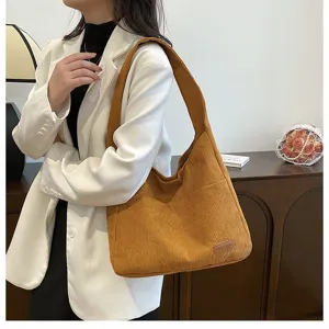 Close-up view of the mustard yellow corduroy texture on a large stylish shoulder tote bag