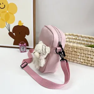 Vista lateral de bolso bandolera de nailon rosa con tierno peluche de oso blanco.