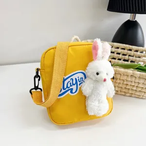 Vista detallada del bolso bandolera amarillo con un tierno peluche de conejo