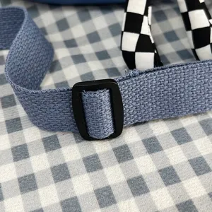 Detalle de la correa tejida azul con hebilla negra ajustable para bolso bandolera