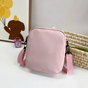 Primer plano de bolso bandolera de nailon rosa con correa ajustable